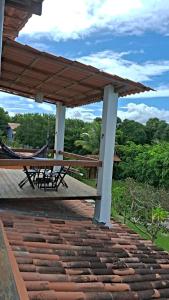 a patio with a table and chairs on a roof at CASA MAR A VISTA in Cumuruxatiba