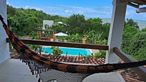 hamak na balkonie z widokiem na basen w obiekcie CASA MAR A VISTA w mieście Cumuruxatiba