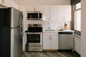 a kitchen with white cabinets and a stainless steel refrigerator at Sonder Gabriel Richard in Detroit