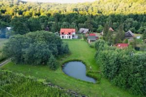 an aerial view of a house and a pond in a field at Selters Guesthouse in Lueta