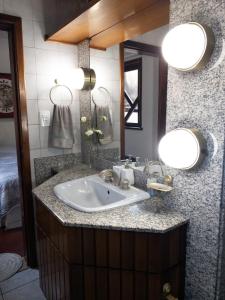 a bathroom with a sink and a mirror at Pousada DRIRIOS HOUSE in Jaraguá do Sul