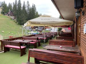 a row of wooden benches and tables on a building at Pansion Vlašić Ski in Šišava