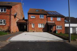 a large driveway in front of a brick house with solar panels at Get Away Home With Hot Tub Sleeps 7 in Peacehaven