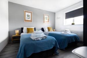 twee bedden met handdoeken in een kamer bij Get Away Home With Hot Tub Sleeps 7 in Peacehaven