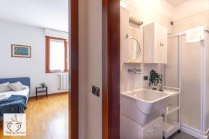 a bathroom with a sink and a bed in a room at FamilyBO Apartments Sant'Orsola in Bologna