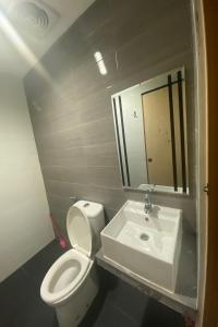 a bathroom with a white toilet and a sink at OYO 92988 City Room in Nagoya