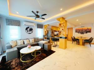 a living room with a couch and a table at Pattaya Aqua Villa - Pool - Kitchen - BBQ - Smart TV in Pattaya South