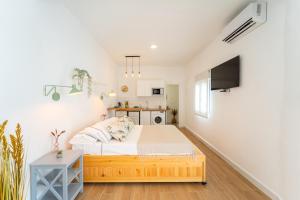 a bedroom with a bed and a small kitchen at Casa La Fontana 2 in Vejer de la Frontera