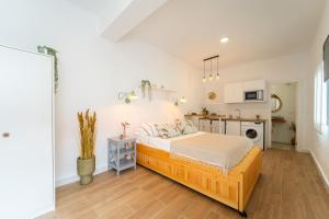 a bedroom with a bed and a kitchen at Casa La Fontana 2 in Vejer de la Frontera