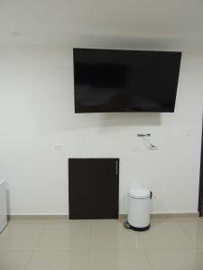 TV de pantalla plana colgada en una pared blanca en Meraki Host, en Cali