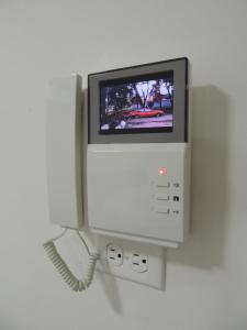 a phone with a television on a wall at Meraki Host in Cali