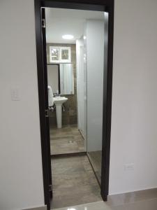 een badkamer met een spiegel en een wastafel bij Meraki Host in Cali