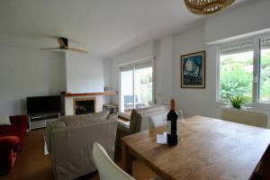 a living room with a table with a bottle of wine on it at Duplex in residential complex with pool in Altea