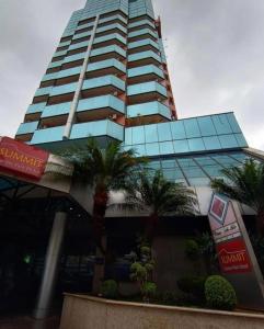 un edificio alto con palmeras delante en Summit Suítes Hotel Jundiaí, en Jundiaí