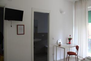 Pokój ze stołem, krzesłem i telewizorem w obiekcie B&B da Antonella w mieście San Donato Milanese