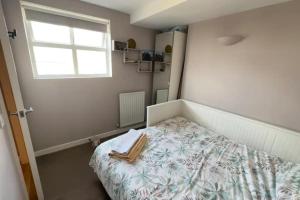 a small bedroom with a bed and a window at Charming 2BD Flat w Chic Terrace Kentish Town in London