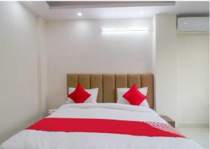 1 dormitorio con 1 cama grande con almohadas rojas en Flagship Leisurrestay, en Nueva Delhi
