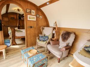 a living room with two chairs and a table at Shire's End in Caynham