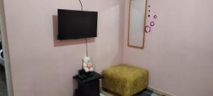 een kamer met een stoel en een televisie aan de muur bij Elegantly furnished 1bedroom at Claycity, Thika Rd in Nairobi