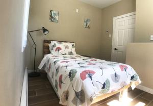 a bedroom with a bed with a comforter on it at Modern, Cheerful 2BD 1BR Apt+Free parking in Halifax