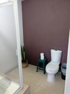 a bathroom with a toilet and a green stool at Casa Las Animas in El Carmen
