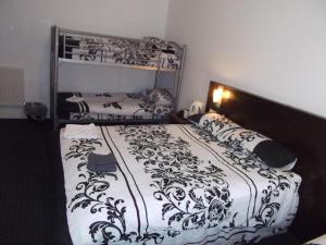 a bedroom with a bed with a black and white comforter at The Woodfield Hotel in Blackpool
