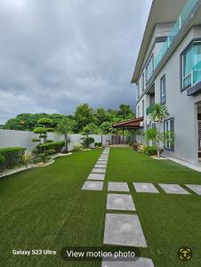 a yard with green grass and a building at Luxurious Home Villa , Ipoh with Karaoke, Snooker for 15-20 pax in Ipoh