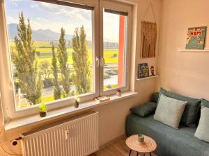 a living room with a window and a couch at Little View in Liptovský Mikuláš