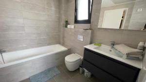 a bathroom with a tub and a toilet and a sink at Apartment in Akko with Sea View in ‘Akko