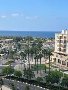 una ciudad con un aparcamiento con palmeras y el océano en Apartment in Akko with Sea View, en Acre