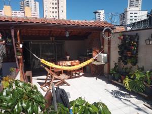 a patio with a hammock on a house at Suíte confortável - banheiro privativo! in Sao Paulo