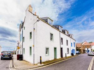 a white building on the side of a street at Pass the Keys Lovely Old Fishermans Cottage in Anstruther