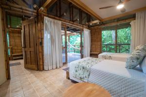 a bedroom with two beds and a large window at La Selva Eco-Lodge & Retreat in Providencia