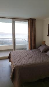 a bedroom with a bed and a large window at Central de Arriendos Nueva Serena in La Serena +68 photos