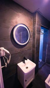 a bathroom with a sink and a round mirror at Boutique Hotel B Plus in Peje