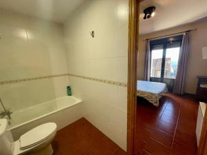 a bathroom with a toilet and a bath tub at Luna de Gredos in Pedro Bernardo