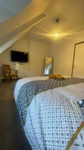 a bedroom with a large bed and a tv at Maison Moderne et Confortable centre Bretagne in Plouguenast Langast