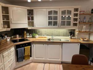 Una cocina con gabinetes blancos y un fregadero. en The old bakery in Sandviken, en Bergen 15 fotos más