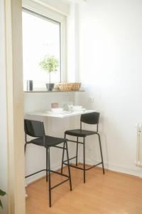 1 mesa y 2 sillas en una habitación con ventana en Stadtoase Wohnung nahe Hauptbahnhof, en Coblenza