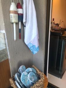 ein Korb mit Handtüchern und einem an der Wand hängenden Handtuch in der Unterkunft Beach Class Eco Life G005 Apartamento térreo in Porto De Galinhas