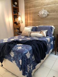 ein Schlafzimmer mit einem blauen und weißen Bett mit Kissen in der Unterkunft Beach Class Eco Life G005 Apartamento térreo in Porto De Galinhas