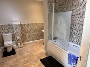 a bathroom with a shower and a tub and a toilet at Crystal Home in Manchester