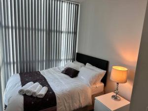 ein Schlafzimmer mit einem Bett mit weißen Handtüchern darauf in der Unterkunft Crystal Home in Manchester
