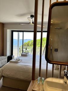 Schlafzimmer mit einem Bett und Blick auf einen Balkon in der Unterkunft Suite de luxe avec vue mer in Sainte-Maxime