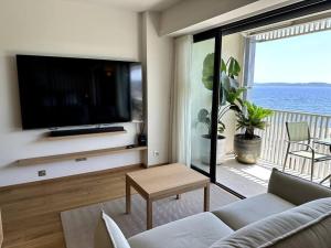 a living room with a tv and a couch and a table at Suite de luxe avec vue mer in Sainte-Maxime