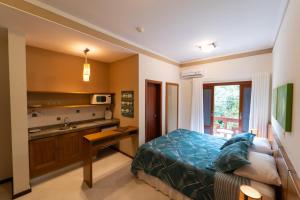 a bedroom with a bed and a kitchen with a sink at Pousada do Almirante in Juquei