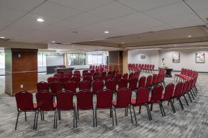 een vergaderzaal met rode stoelen en een podium bij Four Points by Sheraton Victoria Gateway in Victoria