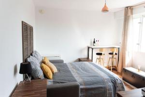 1 dormitorio con 1 cama con manta azul y almohadas amarillas en Studio Gare Saint Jean, en Burdeos