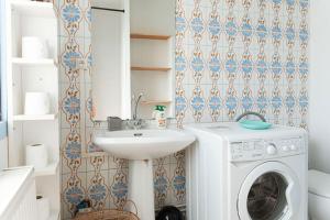 ein Badezimmer mit einer Waschmaschine und einem Waschbecken in der Unterkunft Studio Gare Saint Jean in Bordeaux