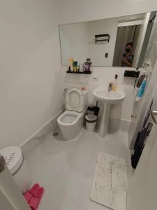 a white bathroom with a toilet and a sink at PRIMEHOMES Cozy Condo with Kitchen Utensils in Manila